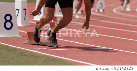 Start race male athletes runners running in starting blocks Start race male athletes runners running in starting blocks 92142328