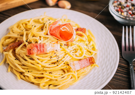 Classic italian pasta carbonara on white plate wooden tabletop, Close-up selective focus Classic italian pasta carbonara on white plate wooden tabletop, Close-up selective focus 92142407