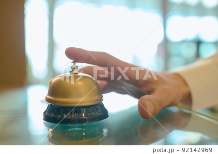 Hand of young male traveler going to press button on bell to call receptionist Hand of young male traveler going to press button on bell to call receptionist 92142969