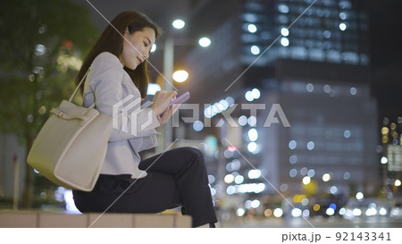 仕事終わりにスマホを見るビジネスウーマン 女性 スマートフォン 92143341