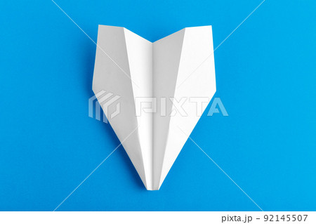 Flat lay of a paper plane on pastel blue color background Flat lay of a paper plane on pastel blue color background 92145507