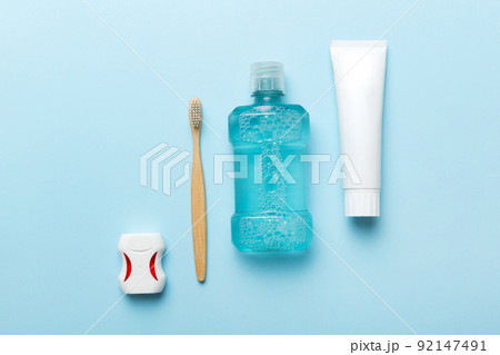 Mouthwash and other oral hygiene products on colored table top view with copy space. Flat lay. Dental hygiene. Oral care products and space for text on light background. concept 92147491