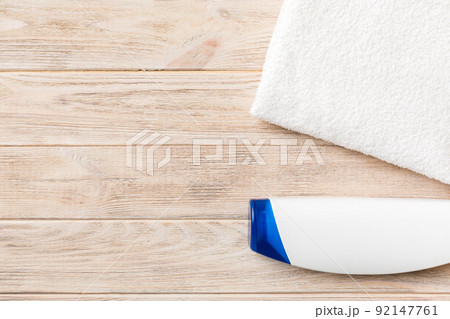 Cosmetic shampoo bottle mockup with towels on a colored table. Bathroom background, toilet accessories for hand and body care 92147761