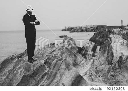 海を見つめるスーツ姿の中年男性 92150808