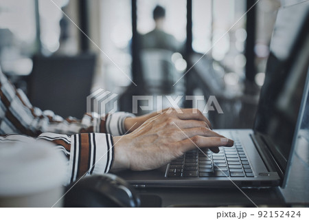 パソコン操作をする女性の手元 92152424