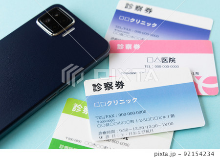 診察券とスマホ　オンライン診療　自宅療養 92154234