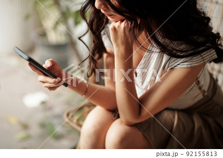 Woman Checking Messages in Smartphone 92155813