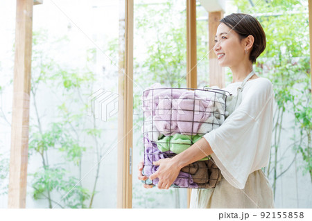 洗濯かごを持つ若い女性 92155858