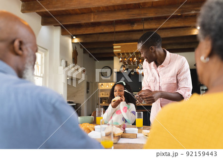 Image of happy multi generation african american family eating breakfast 92159443