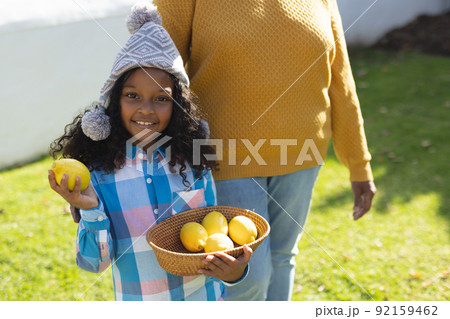 Image of happy african american girl with grandmother holding bowl with lemons Image of happy african american girl with grandmother holding bowl with lemons 92159462