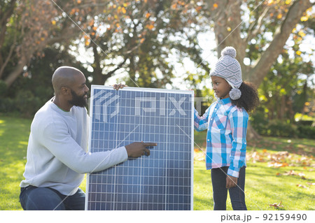 Image of happy african american father showing solar panels to daughter Image of happy african american father showing solar panels to daughter 92159490
