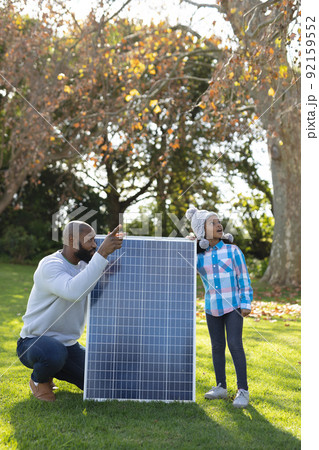 Vertical image of happy african american father showing solar panels to daughter Vertical image of happy african american father showing solar panels to daughter 92159552