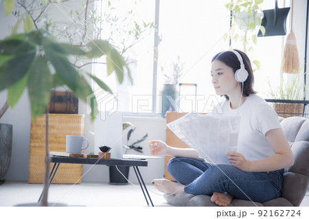 明るい室内でイヤホンとノートパソコンでオンライン授業、リモートワークをする日本人女性 92162724