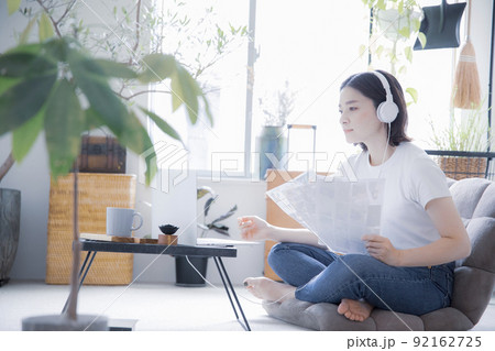 明るい室内でイヤホンとノートパソコンでオンライン授業、リモートワークをする日本人女性 92162725