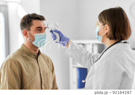 doctor with thermometer and man at hospital 92164287