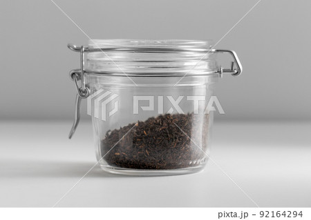 close up of jar with black tea on white table close up of jar with black tea on white table 92164294