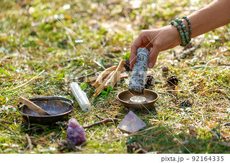 woman or witch performing magic ritual in forest 92164335