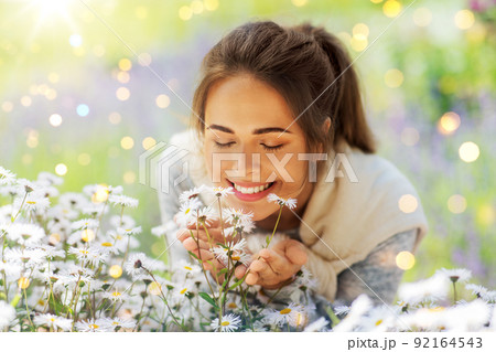 close up of woman smelling chamomile flowers 92164543