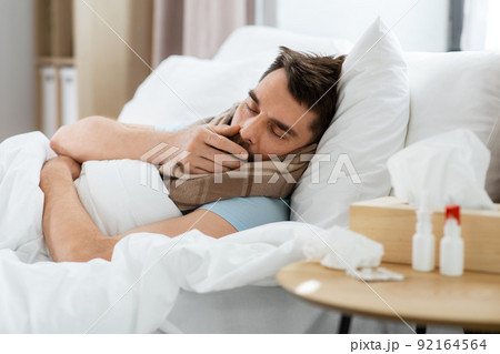 sick man coughing in bed at home 92164564