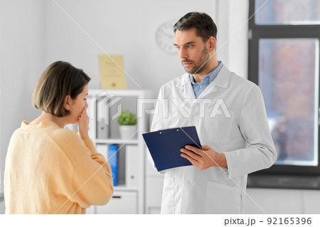 male doctor and coughing woman at hospital 92165396