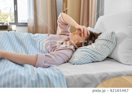 sleepy girl lying in bed at home in morning sleepy girl lying in bed at home in morning 92165467
