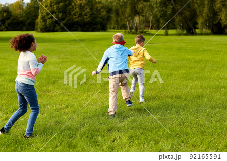 happy children playing and running at park 92165591