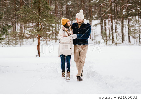 happy smiling couple walking in winter forest happy smiling couple walking in winter forest 92166083