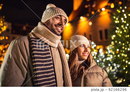 happy smiling couple over christmas lights 92166296