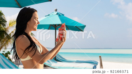 smiling woman in bikini with sunscreen on beach smiling woman in bikini with sunscreen on beach 92166371