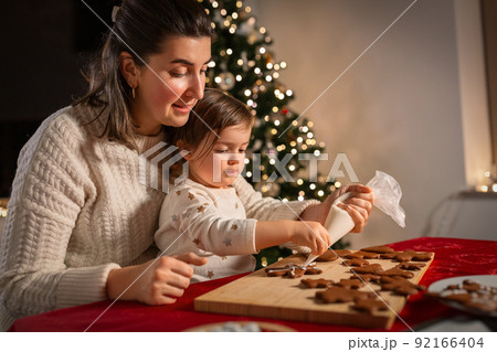 mother and daughter decorating gingerbread at home mother and daughter decorating gingerbread at home 92166404
