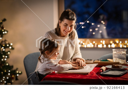 mother and daughter making gingerbread at home 92166413