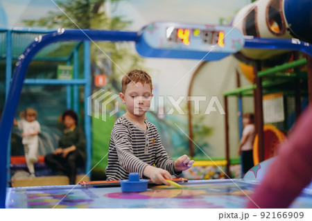 little child plays in air hokey in Entertainment Center 92166909