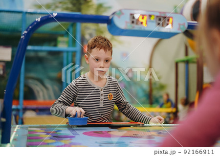 little child plays in air hokey in Entertainment Center 92166911