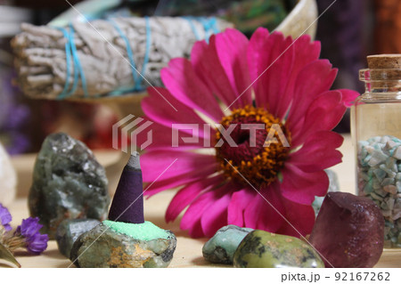 Incense Cone on Stone Slab With Crystals and Flowers Incense Cone on Stone Slab With Crystals and Flowers 92167262