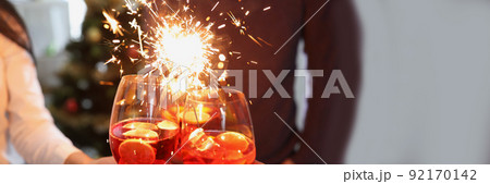 People raise fire sparklers and glass filled with champagne and celebrate winter holiday together 92170142