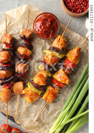 Concept of tasty food with chicken shashlik on gray textured background Concept of tasty food with chicken shashlik on gray textured background 92173905