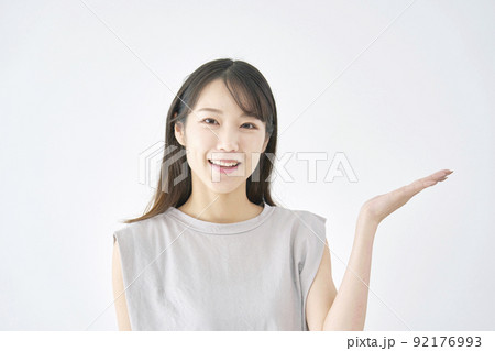 右側を掌で指す女性　白バック 92176993
