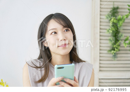 リビングでスマホを使う女性 92176995