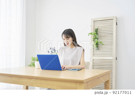 リビングでノートパソコンを使う女性 リビングでノートパソコンを使う女性 92177011