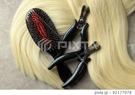 Composition with hair extension accessories on gray textured background Composition with hair extension accessories on gray textured background 92177078