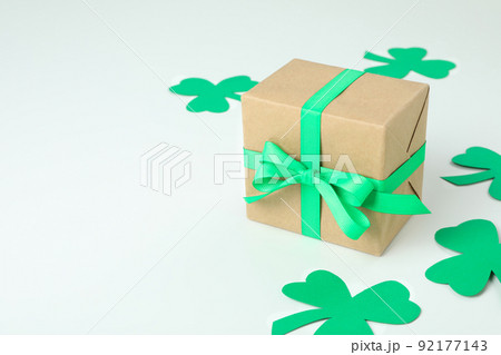 Clover leaves and gift box on white background Clover leaves and gift box on white background 92177143