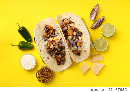 Concept of tasty food with taco on yellow background 92177886