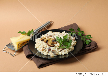 Concept of tasty food with risotto with mushrooms on beige background Concept of tasty food with risotto with mushrooms on beige background 92177948