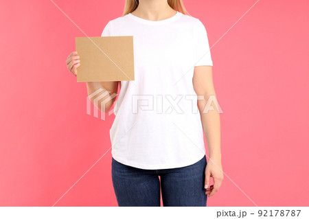 Woman in white t-shirt with space for text on pink background 92178787