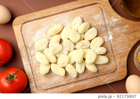 Concept of cooking with potato gnocchi on brown background Concept of cooking with potato gnocchi on brown background 92179807