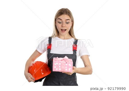 Builder girl with gift box isolated on white background Builder girl with gift box isolated on white background 92179990
