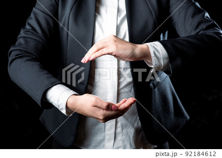 Businesswoman Holding Important Message Between Hands. Woman In Suit Showing New Crutial Idea Among Palms. Executive Presenting Updated Critical Information. 92184612