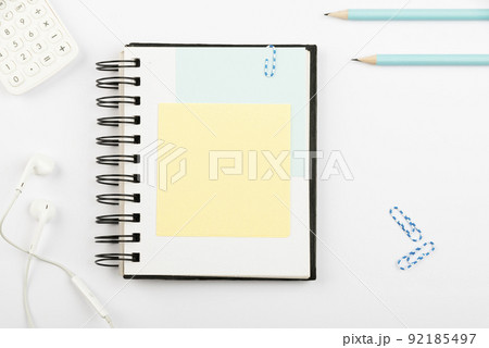 Notebook With Important Message On Desk With Pens, Calculator, Headphones And Paperclips. Notepad With Crutial Information On Table With Pencils And Colored Clips. 92185497