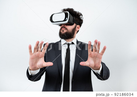 Man Wearing Vr Glasses And Presenting Important Messages Between Hands. Businessman Having Virtual Reality Eyeglasses And Showing Crutial Informations. Man Wearing Vr Glasses And Presenting Important Messages Between Hands. Businessman Having Virtual Reality Eyeglasses And Showing Crutial Informations. 92186034
