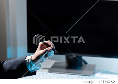 Businesswoman Holding Pen And Pointing On Important Messages On Table With Computer And Keyboard. Woman Presenting Crutial Information With One Hand. 92186252